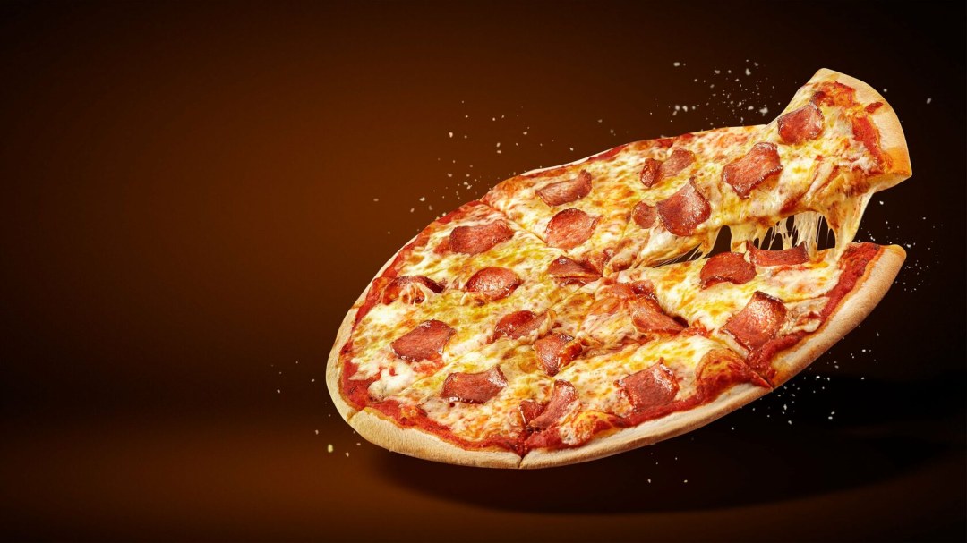 Un pedazo de pizza sobre un fondo negro