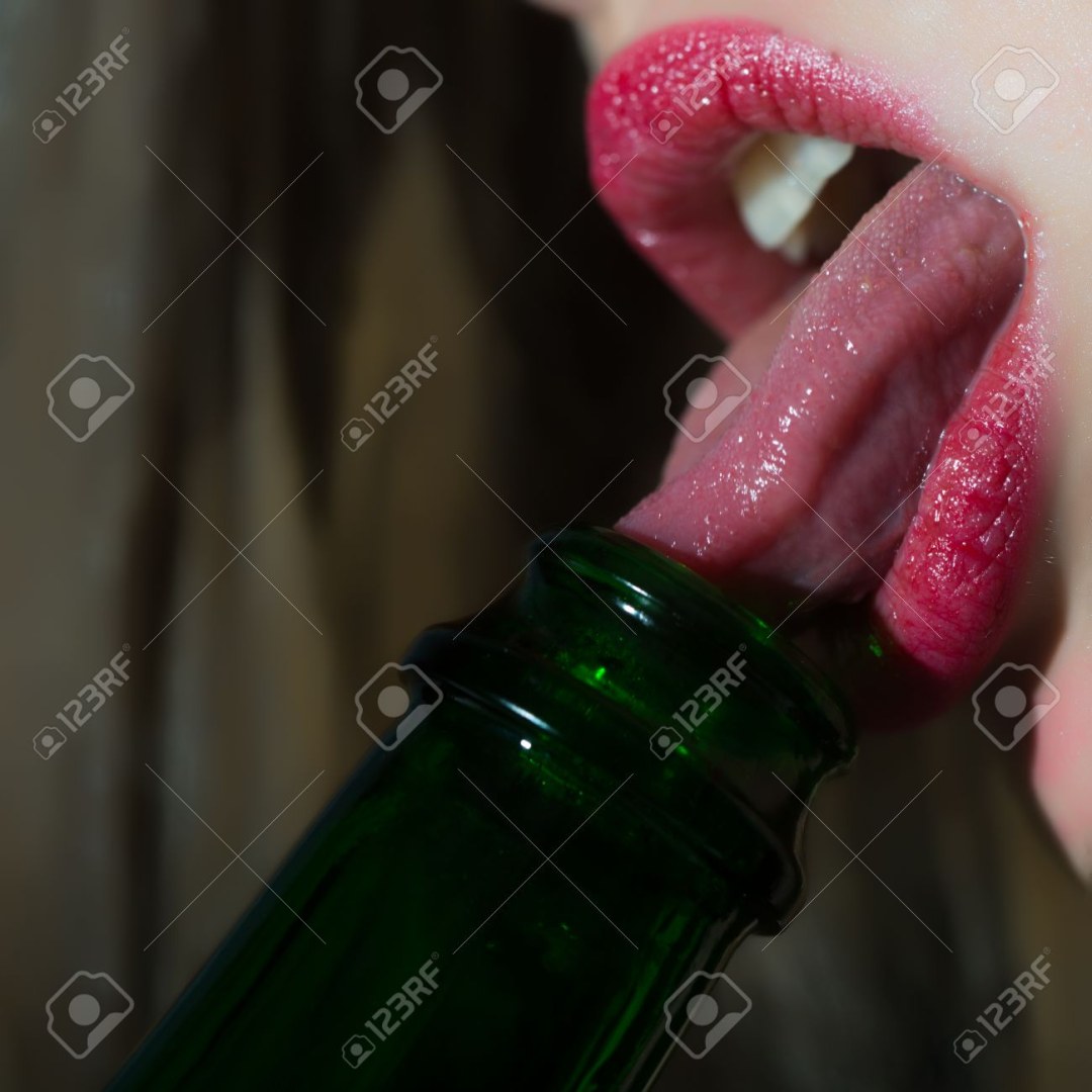 La niña lame el cuello de la botella