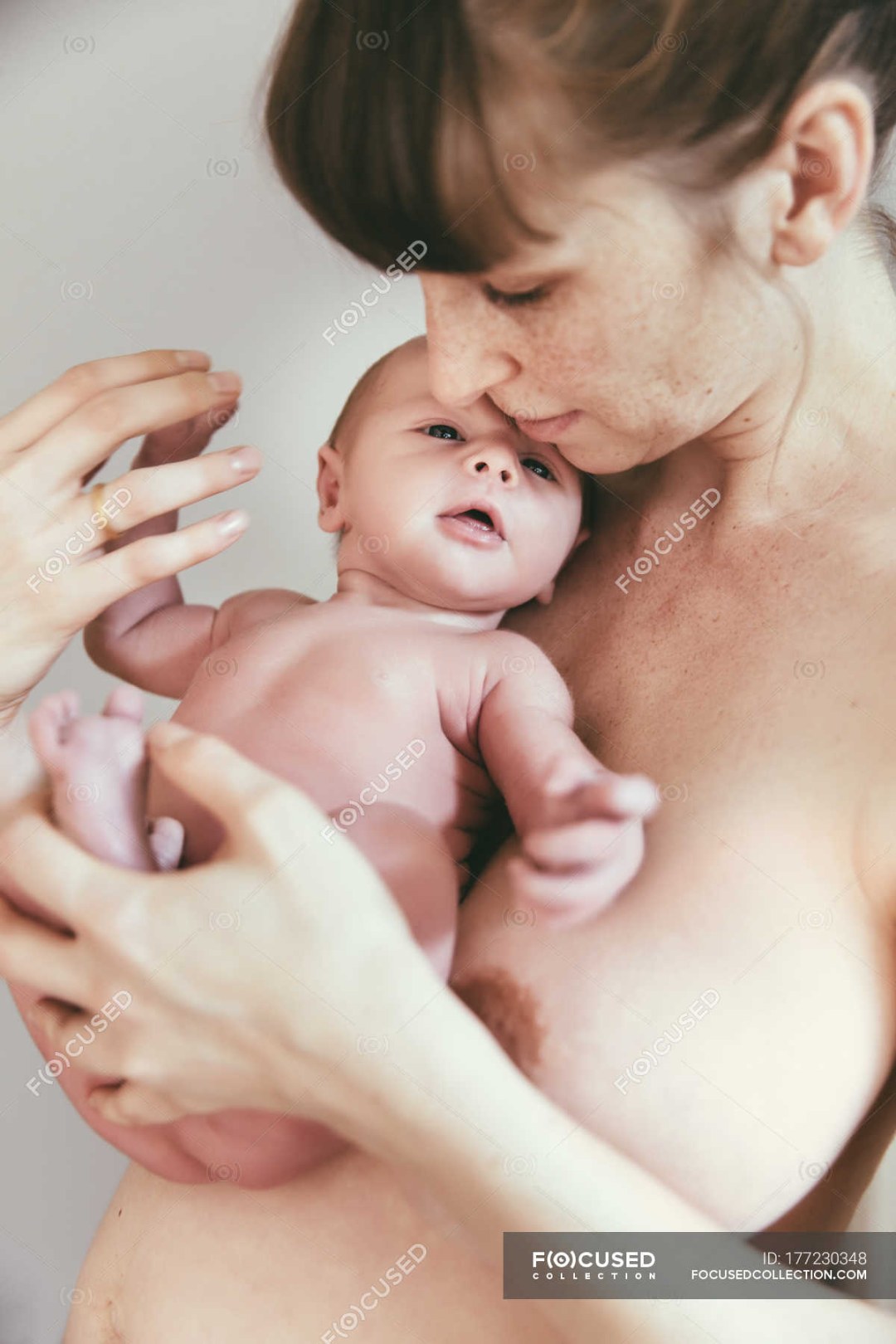 Mamá sostiene un bebé desnudo