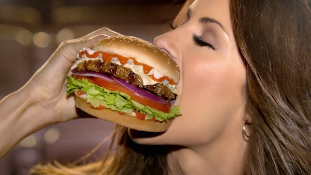 La mujer come hamburguesas