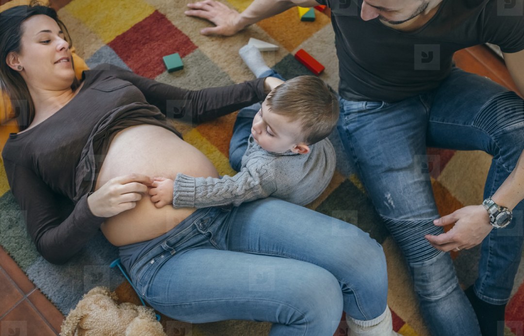 Mamá y papá abrazan el dibujo de la barriga