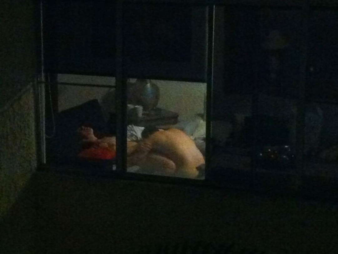 Vecinos desnudos en la ventana opuesto