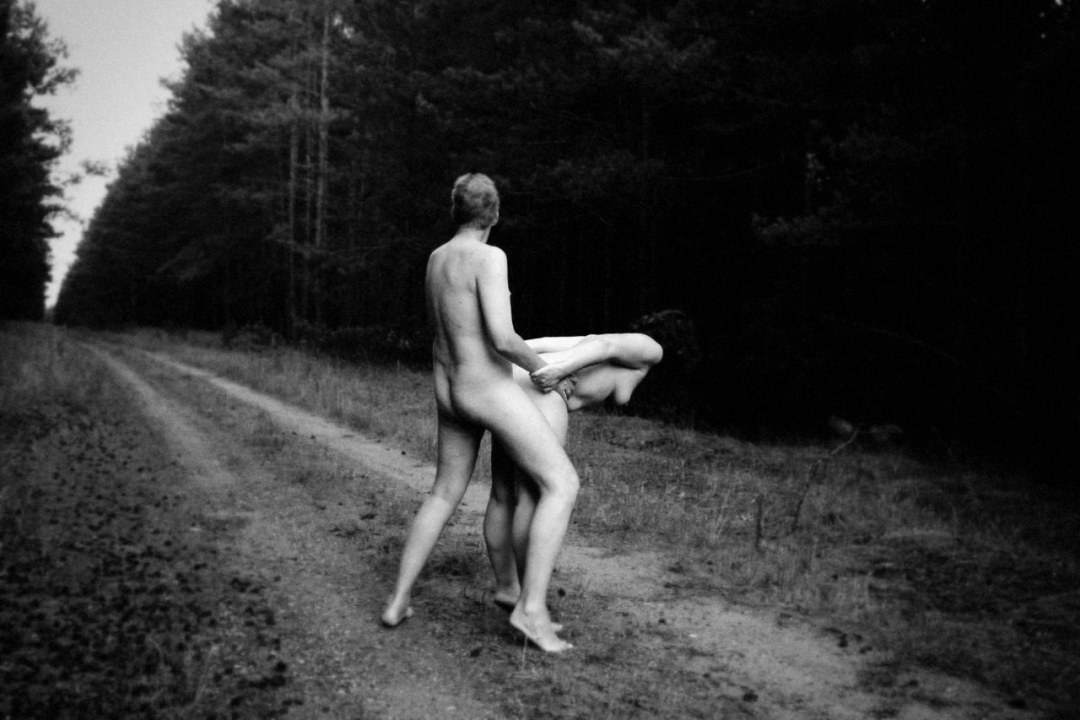 Hombres y mujeres desnudos en el bosque