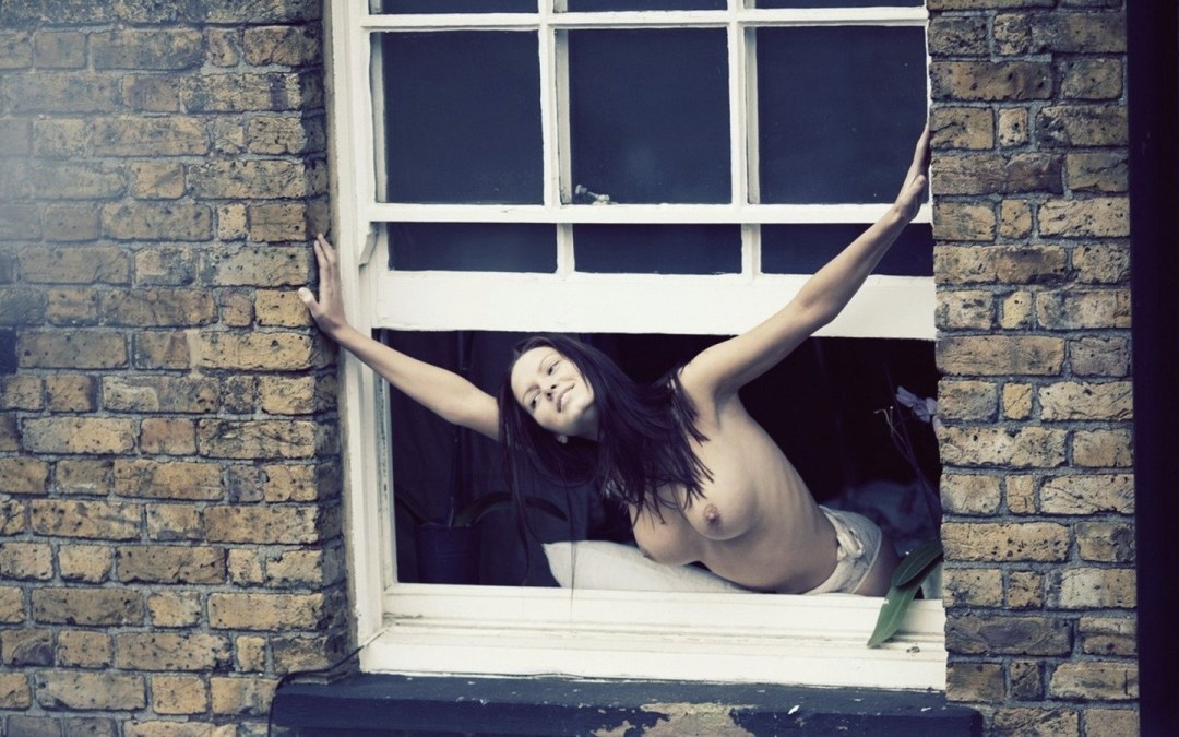 La niña se desnuda en la ventana