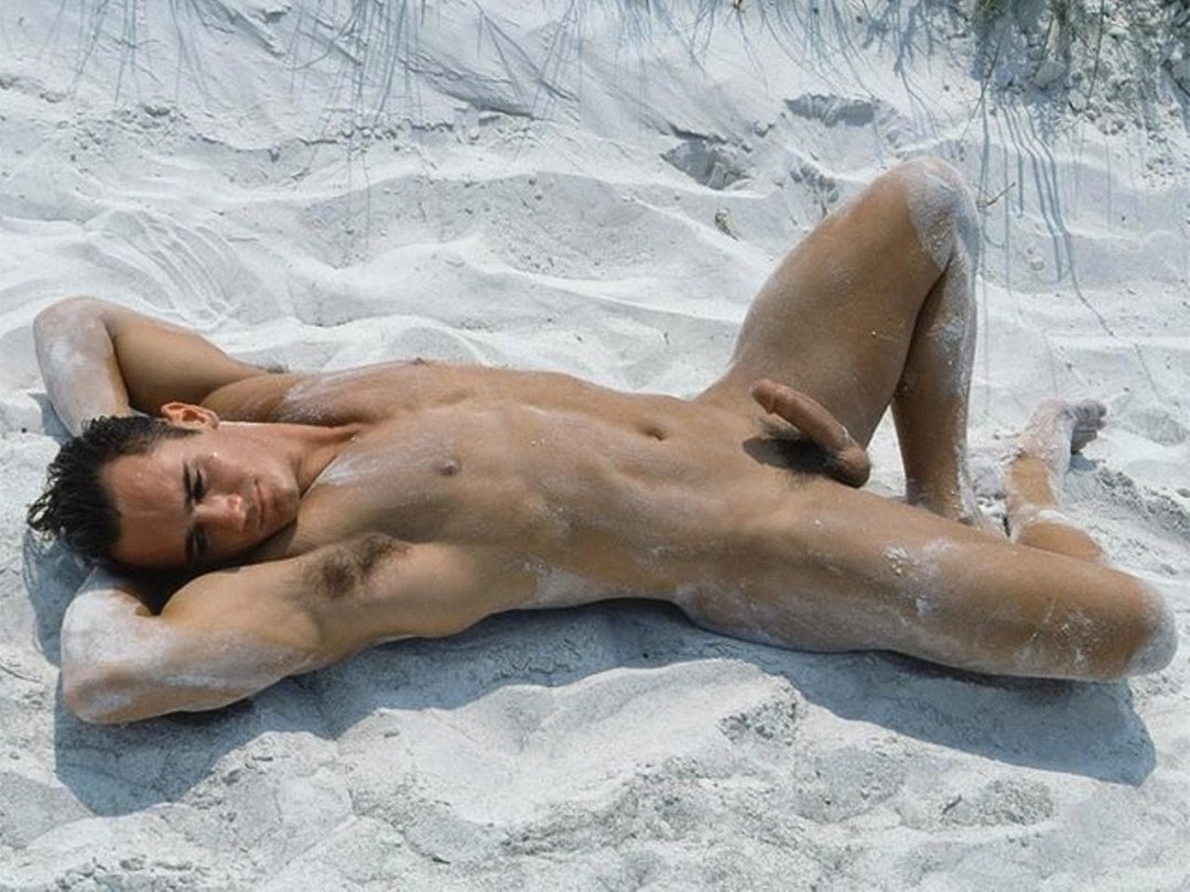 Un chico desnudo yace en la playa