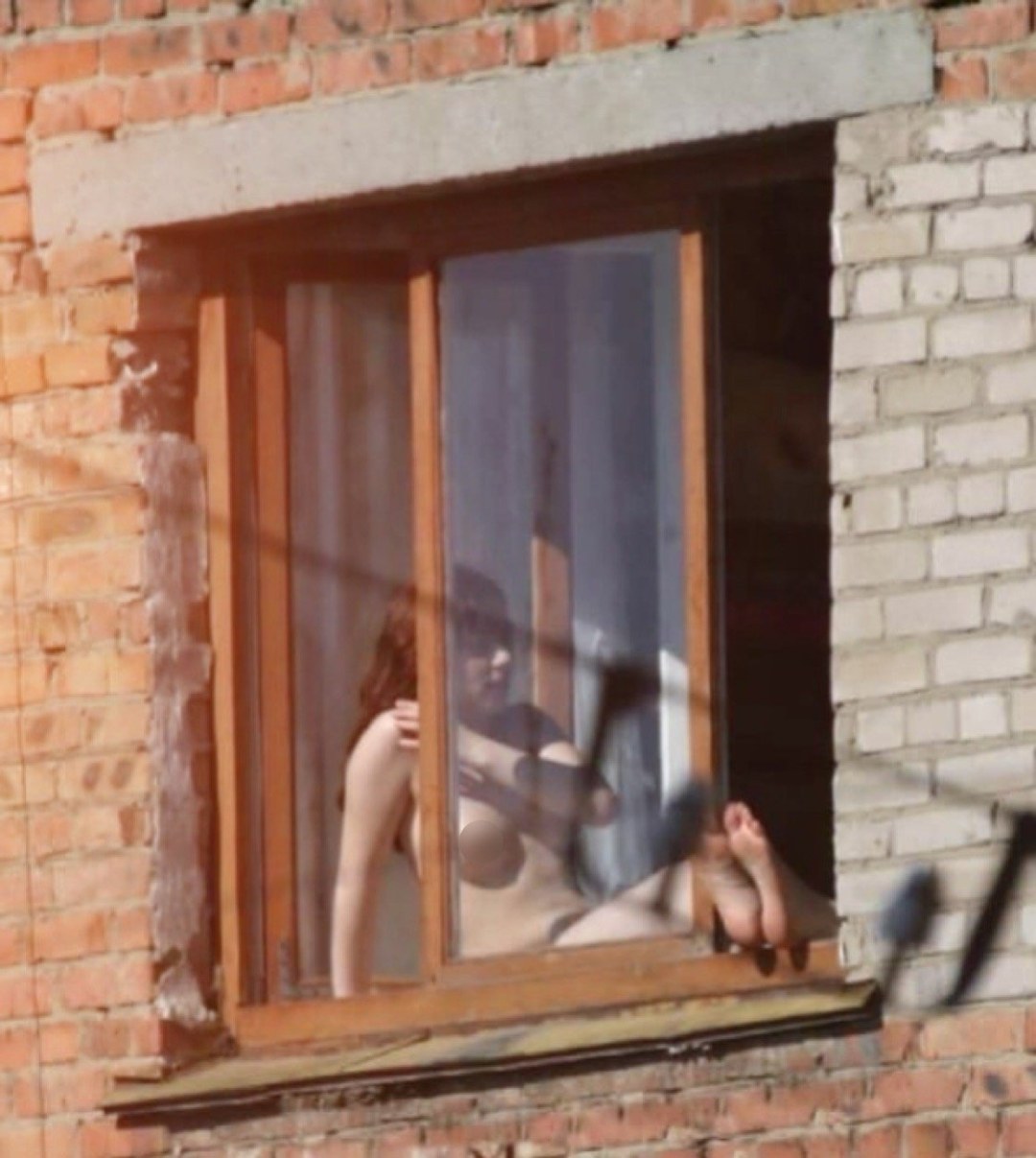 Mujeres desnudas en las ventanas de las casas
