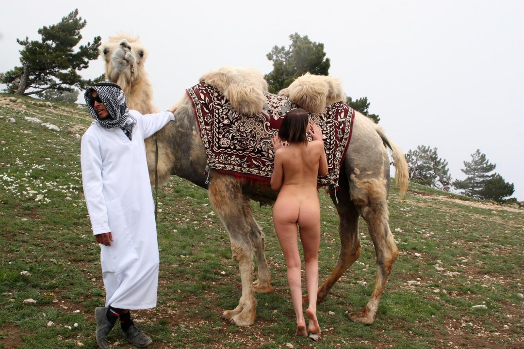 Desnudo con un camello en el desierto