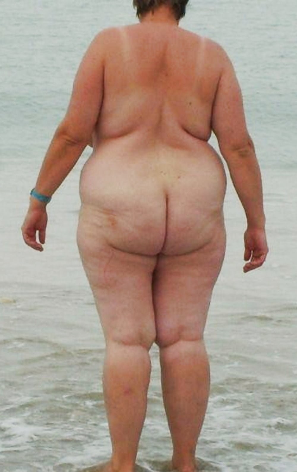 Anciana desnuda en la playa
