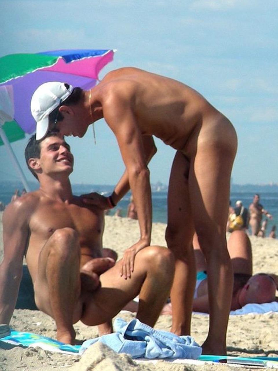 Chicos desnudos en una playa llena