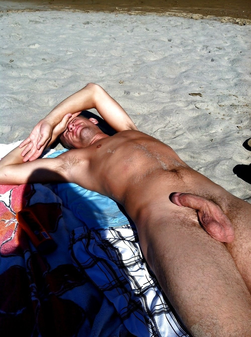 Un chico desnudo yace en la playa
