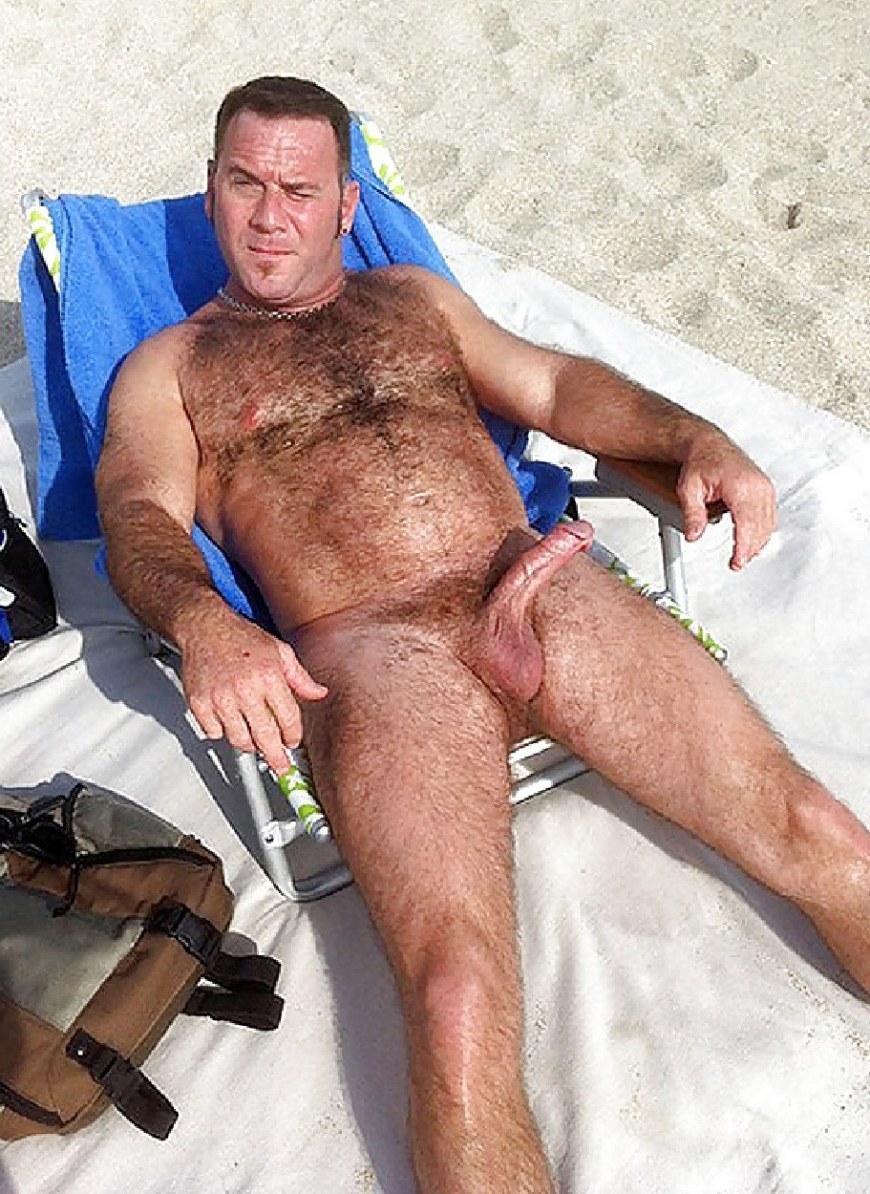 Hombre adulto desnudo en la playa
