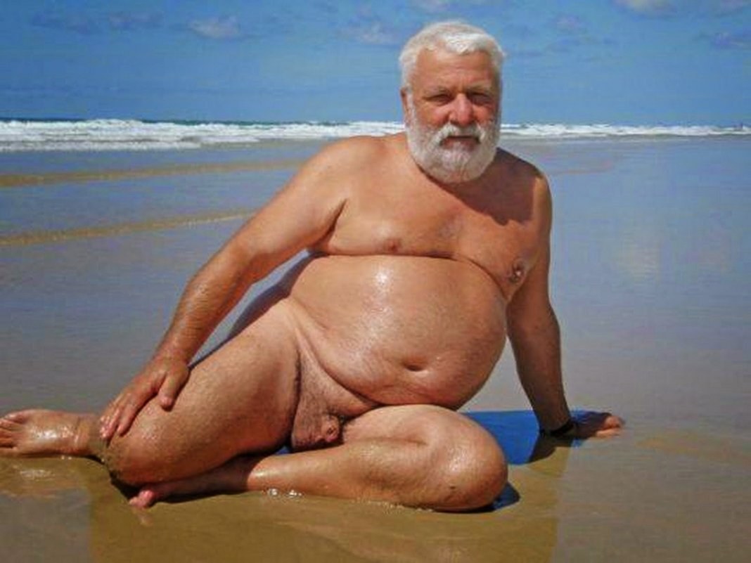 Hombre gordo desnudo en la playa