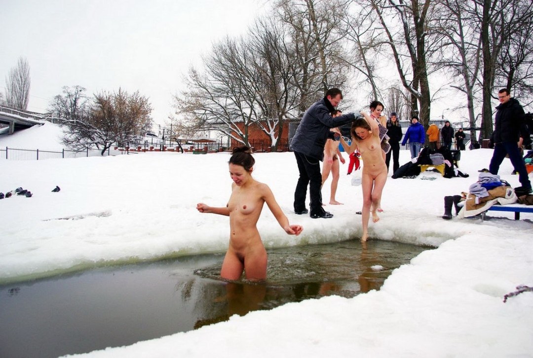 Chicas desnudas bañadas en un agujero de hielo