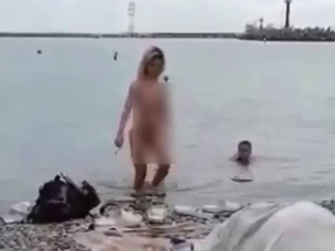 Turista desnudo en la playa en Sochi