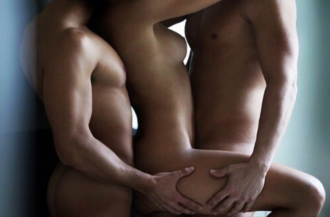 Hombre y dos mujeres desnudas se abrazan