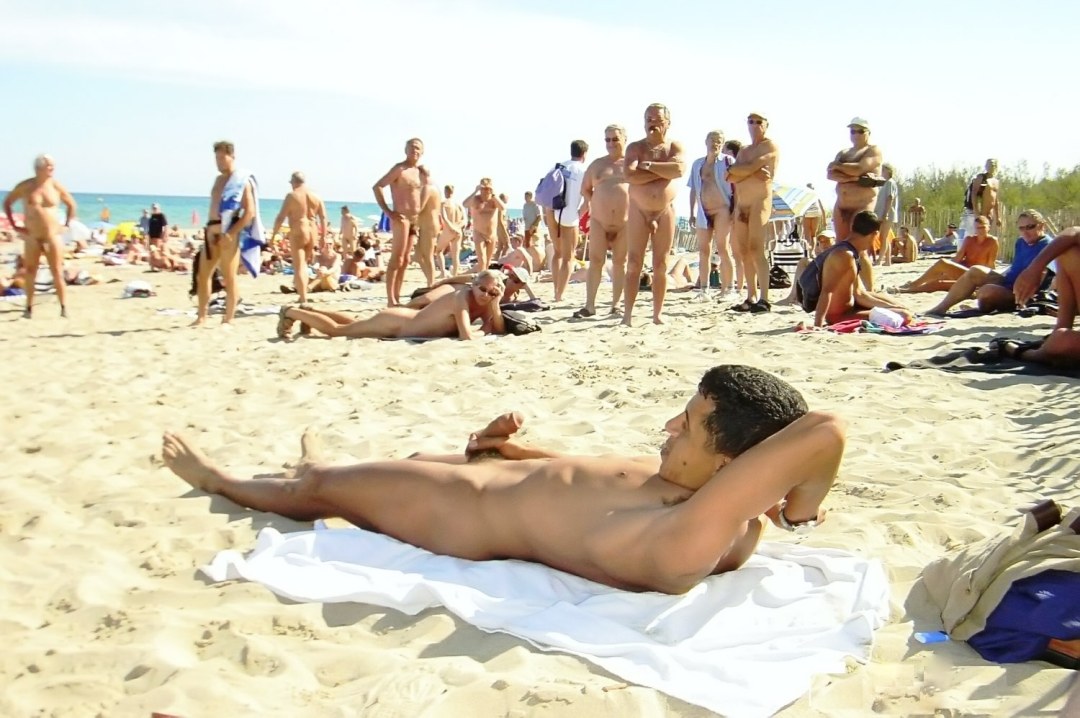Chicos desnudos en una playa llena