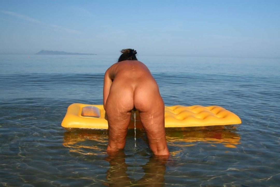 Mujer desnuda vertiendo en el mar