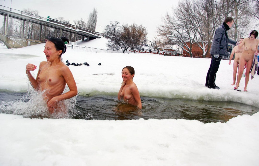 Las mujeres desnudas se bañan en un agujero de hielo después de una casa de baños