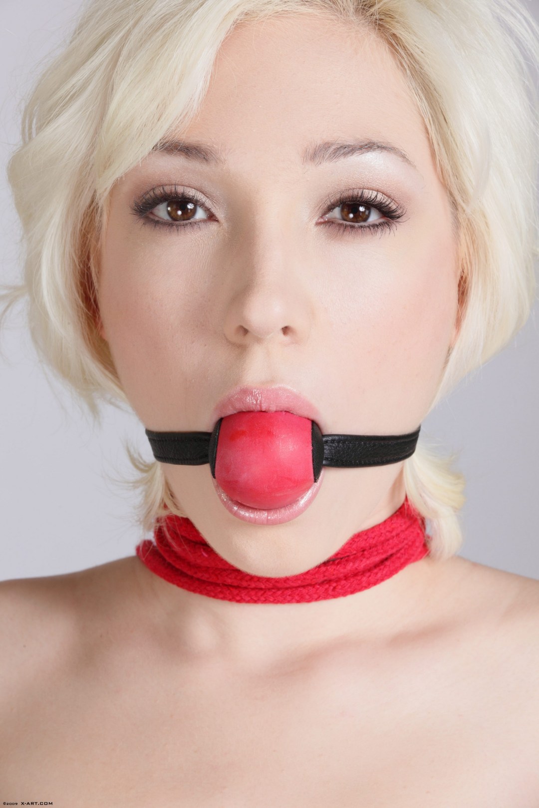 Mordaza rubia desnuda en la boca