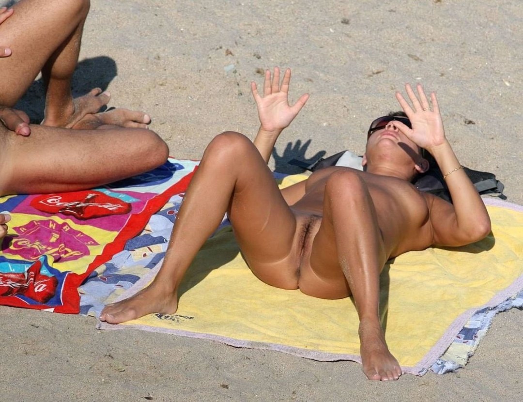 Tomando el sol en la playa extendiendo sus piernas