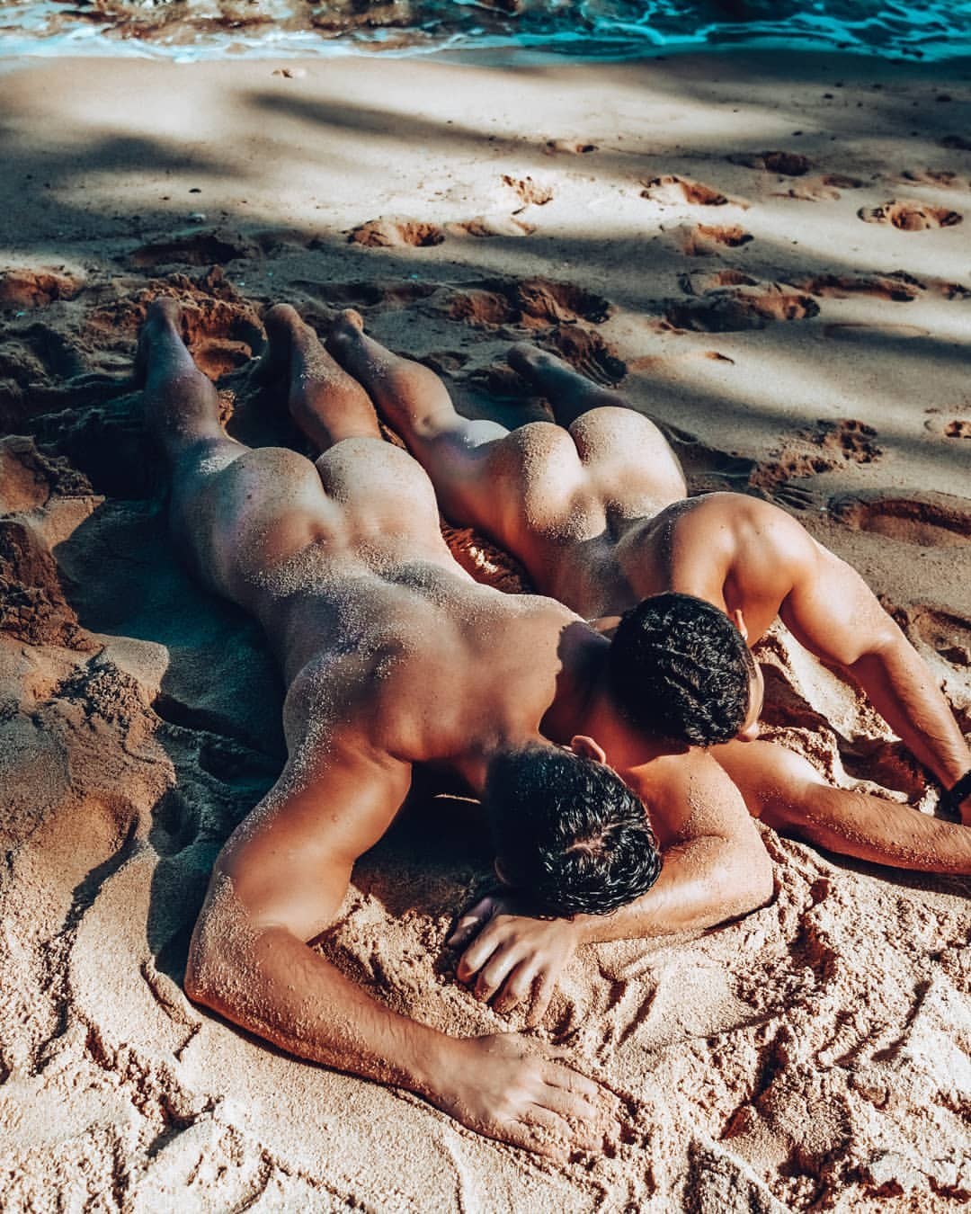 Un chico desnudo yace en la playa