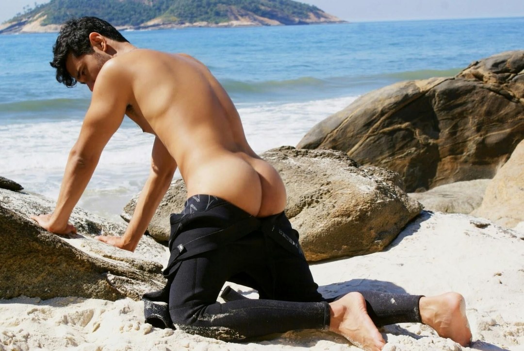 Chicos de trasero desnudo en la playa