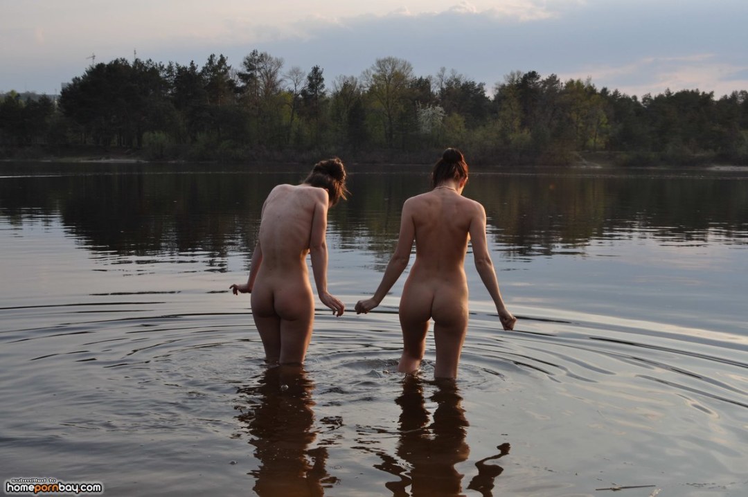 Las mujeres desnudas se bañan en el río por la noche