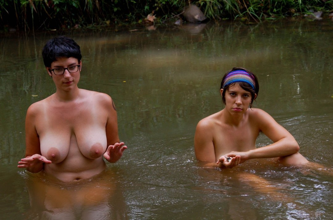 Las mujeres desnudas se bañan en el río