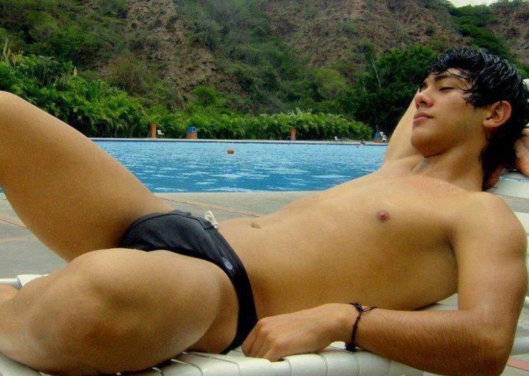 Chico en troncos de natación en la playa
