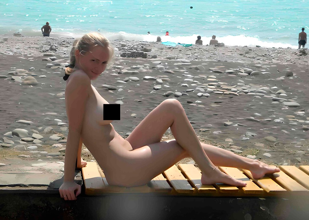 Pequeña rubia desnuda en la playa