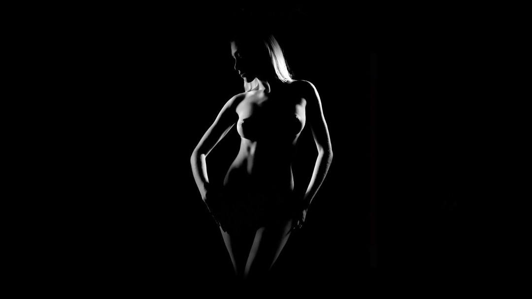 Голая блондинка на черном фоне