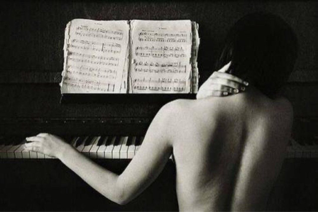 Женщина лежит на рояле